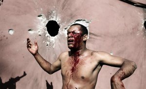 Солдаты Коморанского и Танзанийского Союза арестовывают травмированного человека после попадания трех ракет в его дом. 25 марта 2008 год. JOSE CENDON/AFP/Getty Images