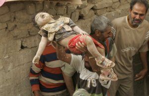 Человек несет тело ребенка из разрушенного дома после воздушного удара в городе Багдад. Ирак. 29 апреля 2008 год. REUTERS/Kareem Raheem
