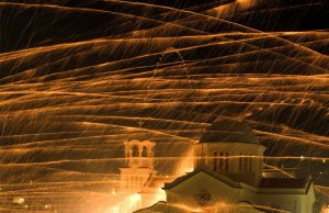 Ракеты пролетают над колокольней Айиос Маркос, греческой церкви, во время празднования православной Пасхи в восточной части Эгейского моря острова Хиос в Греции. 26 апреля 2008 год. REUTERS/Yiorgos Karahalis