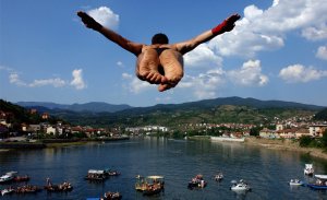 Спортсмен в ходе ежегодных соревнований по высотным прыжкам в воду, прыгает с высоты 14-ти метрового моста в реку Дрина в боснийском городе Вышеграде. 12 июля 2008 год. REUTERS/Stringer